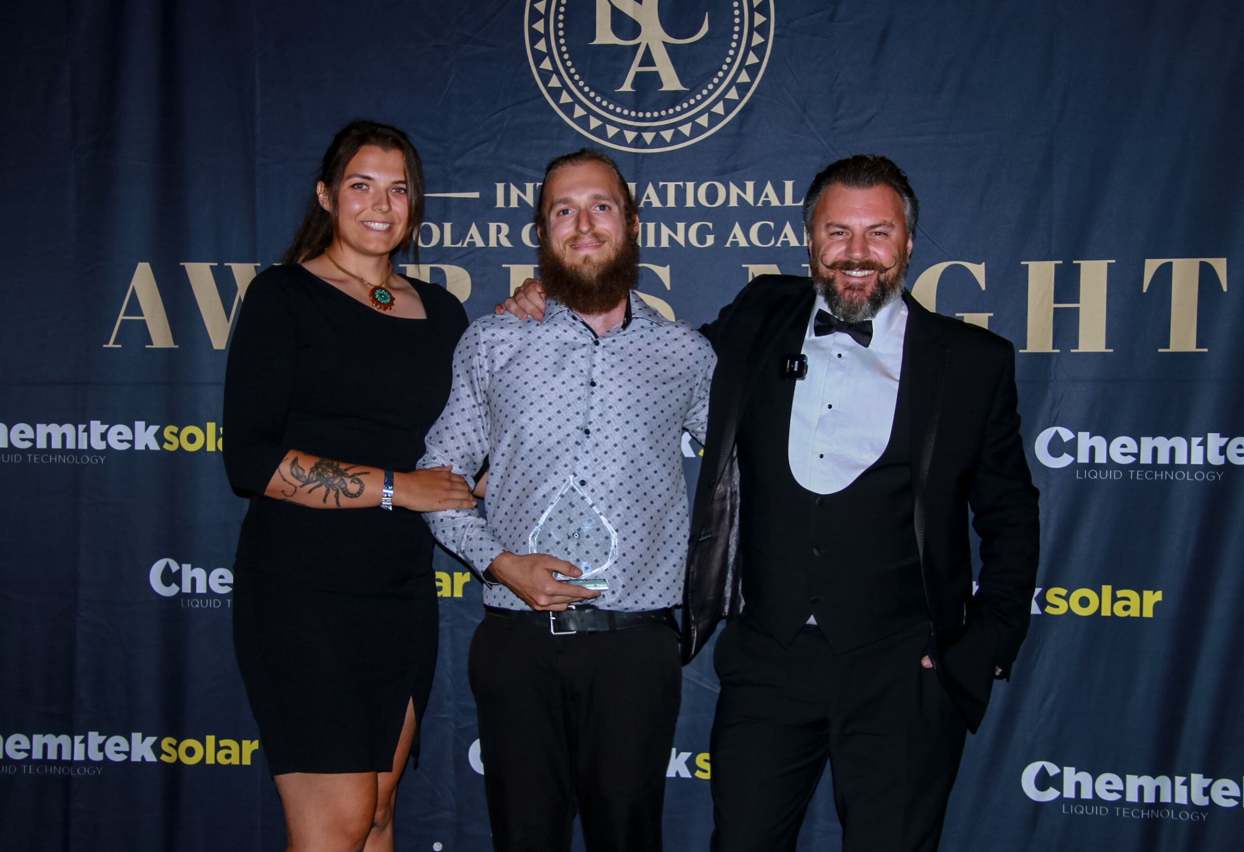 3 people receiving glass award