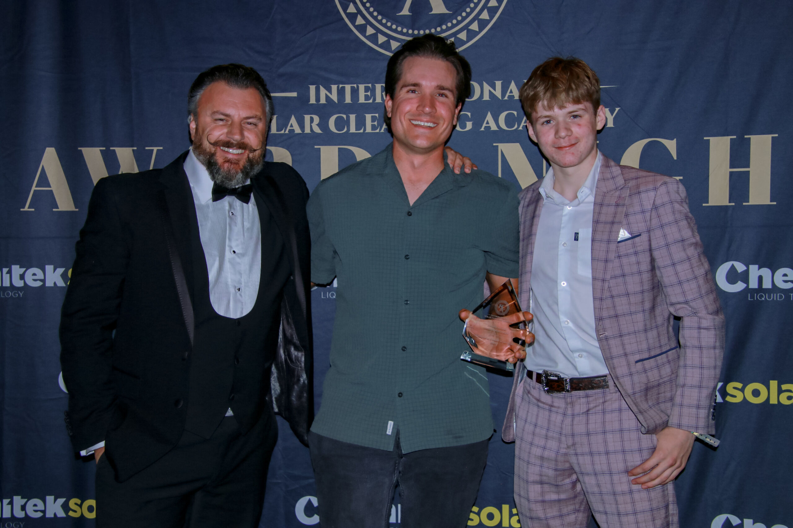 Three people presenting glass award