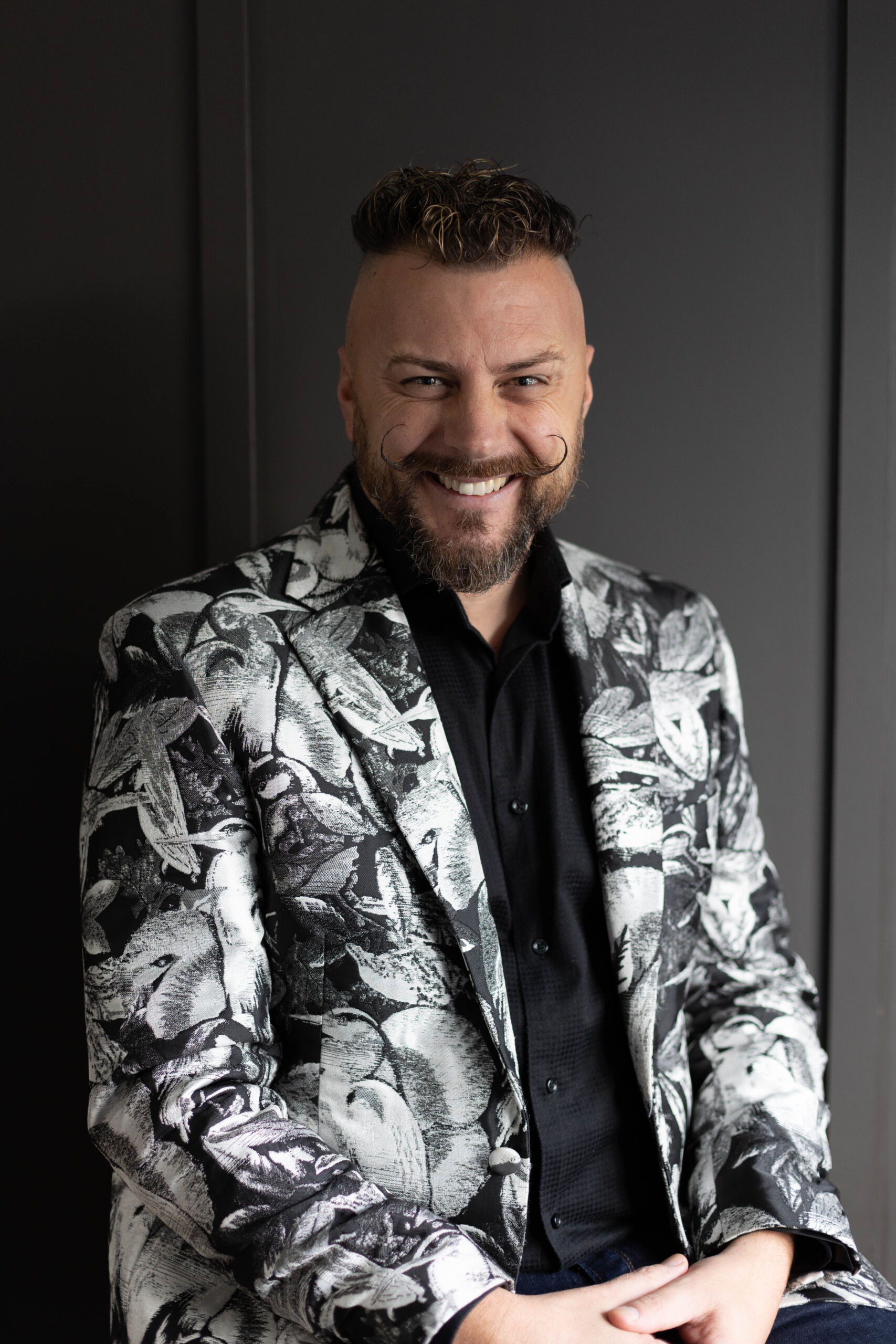 a headshot of a man in a black and white jacket